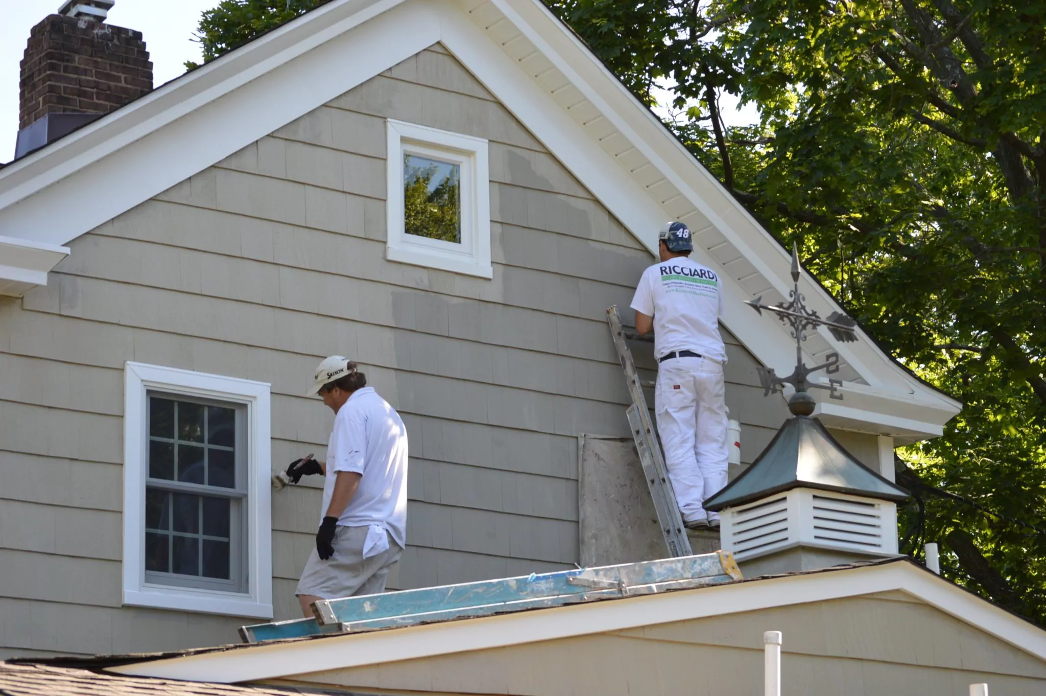Professional exterior painters working on a house in Thornton, CO
