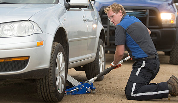 Emergency tire repair service fixing a flat tire on the roadside